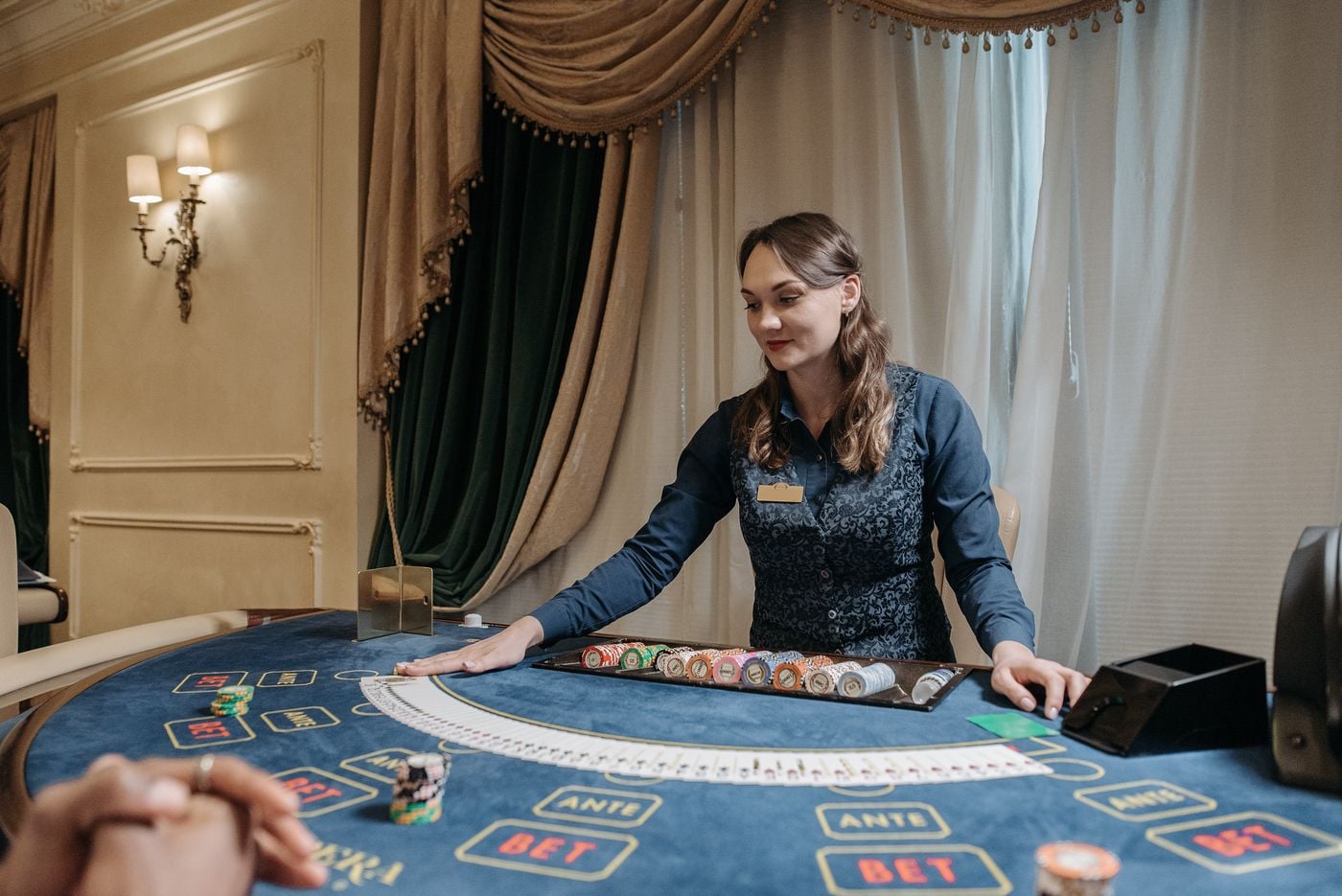 Smiling dealer spreading cards at a live blackjack table