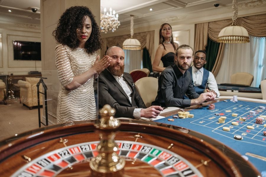 Guests in evening wear around a roulette table
