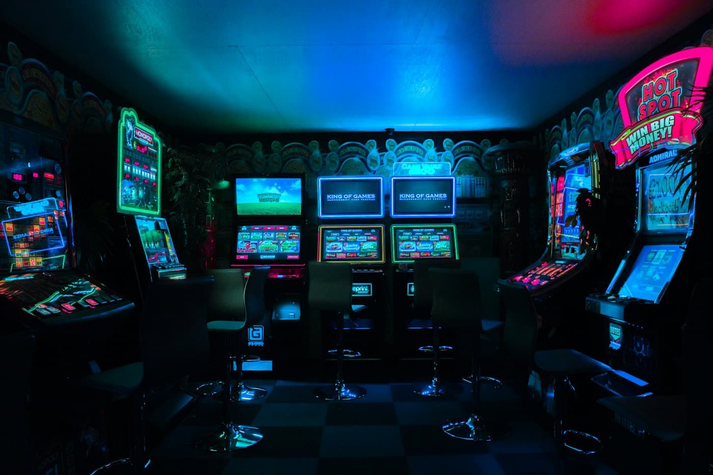 Dark arcade room lit by neon cabinet screens