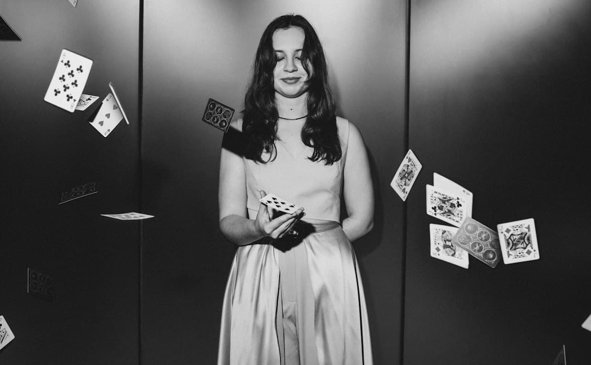 Young woman with playing cards falling around her