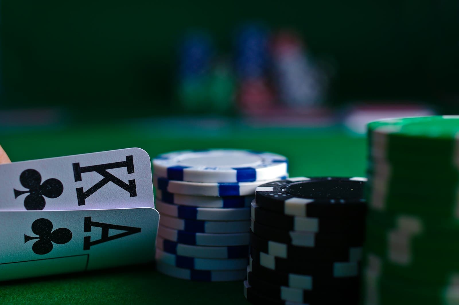 King and ace of clubs beside stacks of poker chips